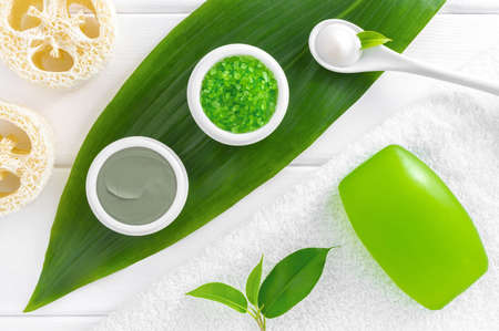 Natural herbal cosmetics: sea salt, cosmetic clay, bath soap and cream on white wooden background. SPA cosmetics concept.の写真素材