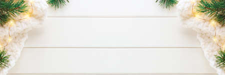 Christmas background with fir branches, knitted blanket and christmas lights. Banner, top view, copy space.の写真素材