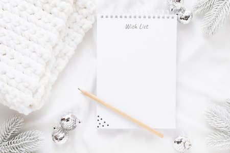 Christmas decorations and notebook with wish list or goals and dreams on white background. Flat lay, top view, copy space.の写真素材