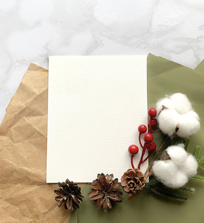Watercolor paper sheet mockup with Christmas decor, paints on a marble background. Mockup for presentation of illustrations, prints, logos, postcardsの写真素材