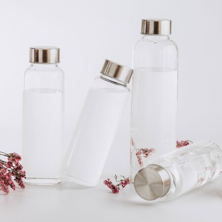 Clear glass water bottles on a bright grey background.の写真素材