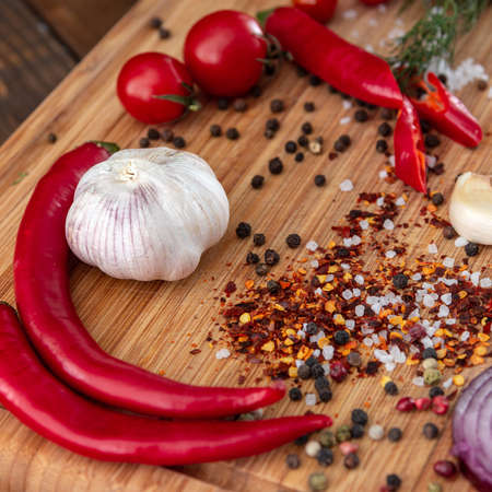 spices onion red pepper garlic on wood boardの写真素材