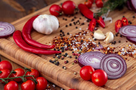 spices onion red pepper garlic on wood boardの写真素材