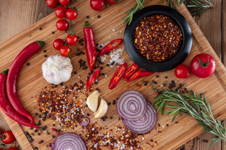 spices onion red pepper garlic on wood boardの写真素材