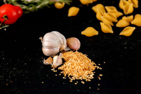 dried garlic garlic on black background with tomatoの写真素材