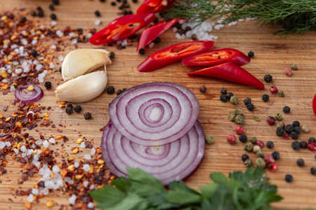 spices onion red pepper garlic on wood boardの写真素材