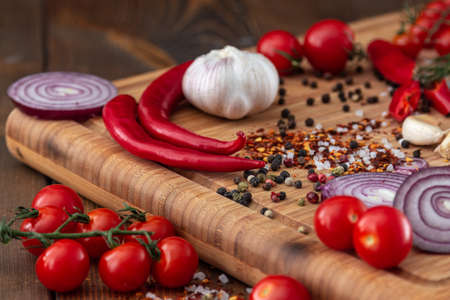 spices onion red pepper garlic on wood boardの写真素材