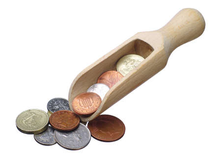 Coins of the British money and wooden spoon isolated on whiteの写真素材