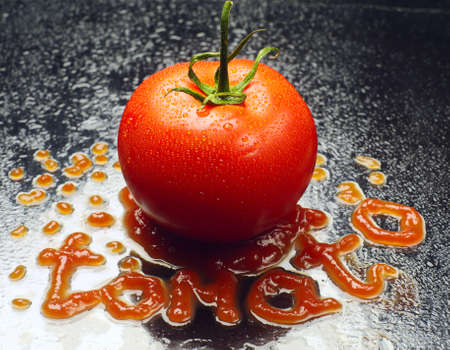 One red tomato and ketchup with water drops の写真素材