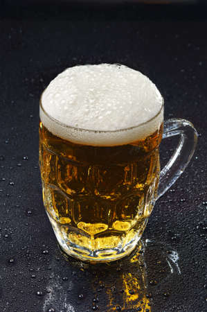 Beer and water drops on black closeupの写真素材