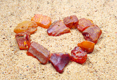 Amber in the shape of a heart in the sandの写真素材