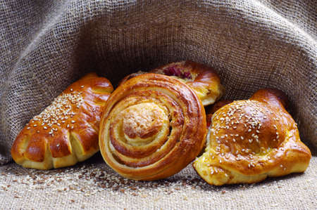 Sweet bread roll against the background of coarse cloth