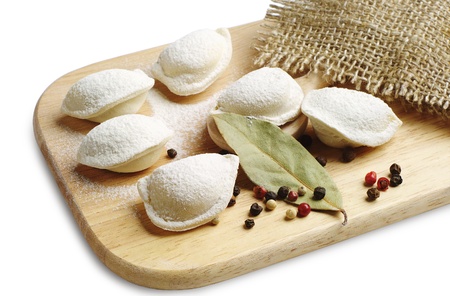 Uncooked meat dumplings on a cutting board on whiteの写真素材