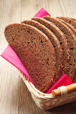 Slices bread in a basket on a wooden tableの写真素材