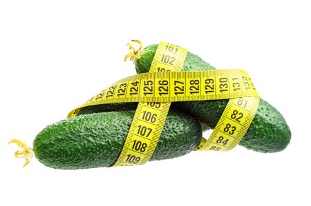 Three fresh cucumbers and measuring tape isolated on whiteの写真素材