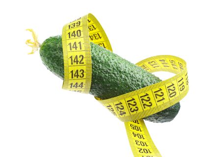 Cucumber and measuring tape isolated on whiteの写真素材