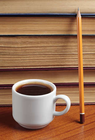 Cup of coffee, book and pencil on tableの写真素材