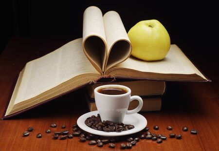 Cup of coffee, apple and opened bookの写真素材