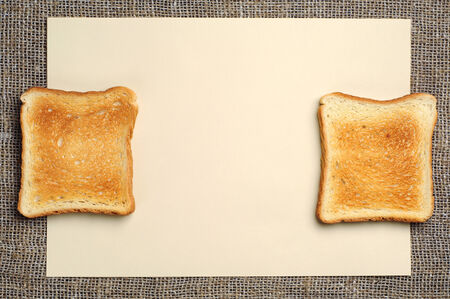 Blank sheet of yellow paper and two slices of toast bread 