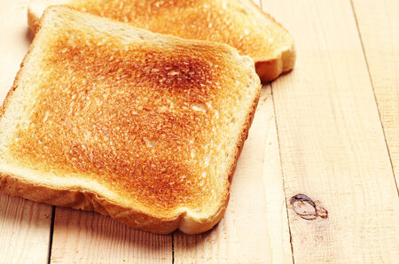 Two toast bread on wooden table closeup