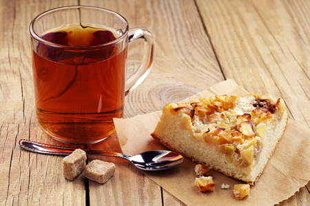Cup of tea and piece pie with apples on wooden tableの写真素材