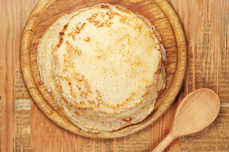 Stack of pancakes on old wooden table. Top view