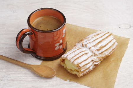 Sweet cake with creamy and cup of coffee on tableの写真素材