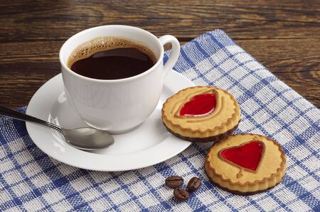 Cup of coffee and cookies with jam on blue tableclothの写真素材