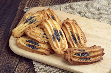 Homemade cookies with poppy in plate on cutting boardの写真素材