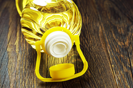 Vegetable oil in plastic bottle on old wooden table closeupの写真素材