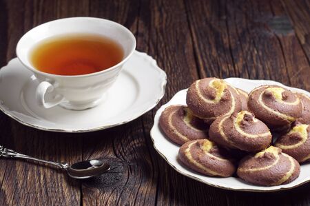 Cup of tea and cookies with chocolate on dark wooden tableの写真素材