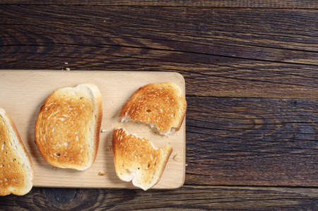 Slices of toast bread on wooden background, top viewの写真素材