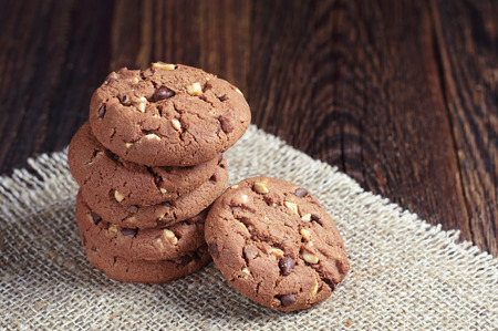 Delicious chocolate cookies with nuts on old wooden table