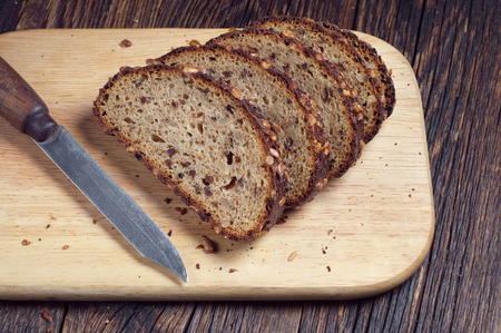 Sliced bread and the knife on chopping board