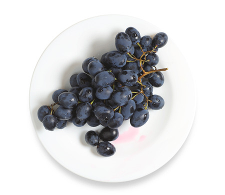 Dark grapes in plate on a white backgroundの写真素材