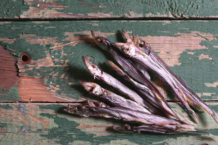 Dried salted capelin on vintage wooden background, top viewの写真素材