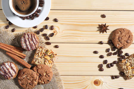 Wooden background with different cookies, cup of hot coffee, and space for your text. Top viewの写真素材