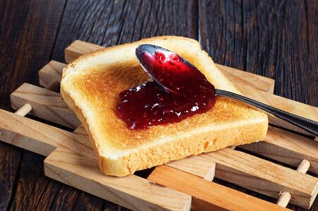 Toasted bread with jam on rustic wooden tableの写真素材