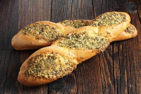 Two small baguettes filled with spice on wooden backgroundの写真素材