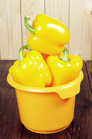 Yellow paprika in bowl on wooden tableの写真素材