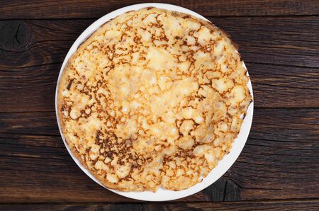 One fried pancake in plate on dark wooden table, top viewの写真素材