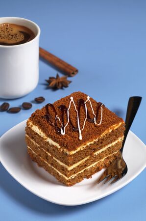 Honey cake and cup of coffee on a blue tableの写真素材