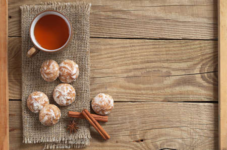 Glazed gingerbread, tea cup and old wooden table background. Top viewの写真素材