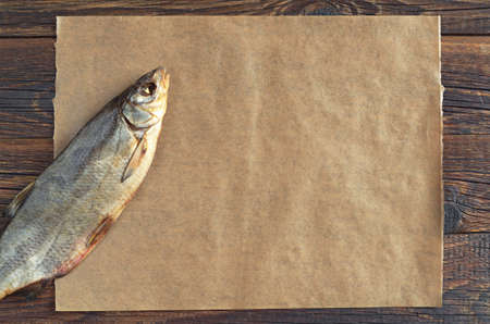 Dried salted fish for beer with empty paper for text on table, top view の写真素材