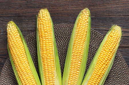 Ripe sweet corn on rustic wooden table, top viewの写真素材