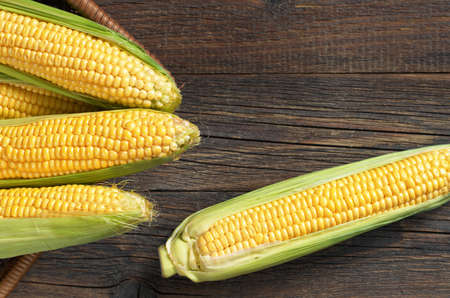 Ripe sweet corn on rural wooden table, top view. Selective focus.