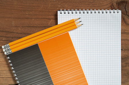 Notepad and pencils on wood table, top view. Space for your text