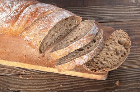 Fresh ciabatta bread sliced on a wooden cutting board