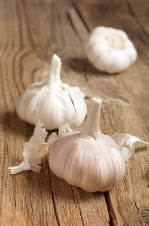 Ripe whole garlic on old wooden tableの写真素材