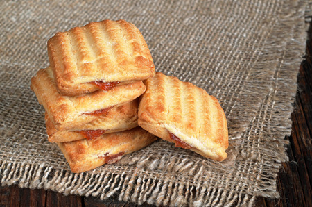 Shortbread cookies with jam on burlap backgroundの写真素材